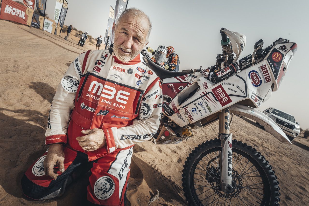 Franco Picco in ginocchio con la sua moto e il deserto sullo sfondo